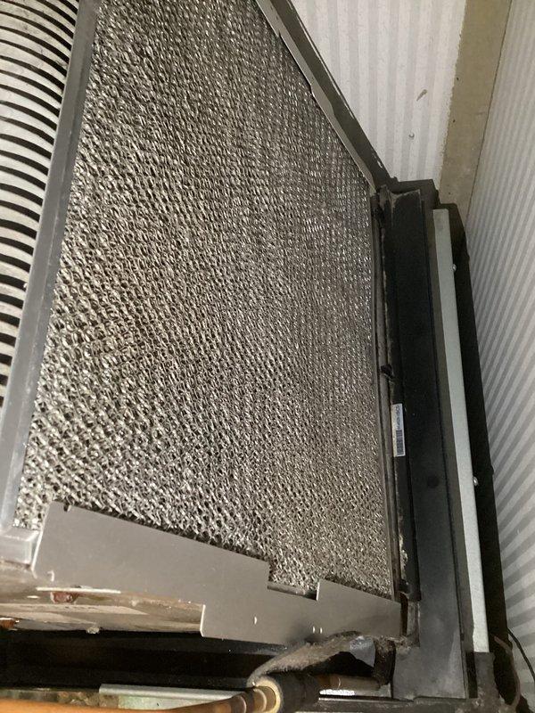 Completed cooling season tune-up on single AC unit located in hallway. Performed comprehensive system inspection including evaporator coil assessment, which revealed significant dust and debris accumulation on coil surface and fins requiring attention for optimal heat transfer efficiency. Evaluated customer-installed thermostat per special request to diagnose reported operational issues. Inspected refrigerant lines, drain pan assembly, and all accessible HVAC components. Documented equipment condition with photos showing evaporator coil assembly, heat exchanger fins, refrigerant piping, and filter housing. System operational upon completion of maintenance procedures.