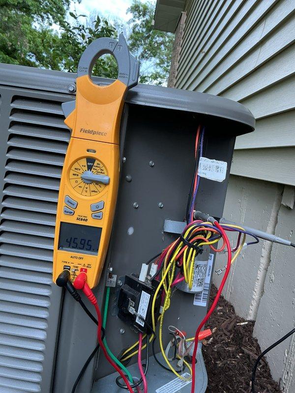 Completed comprehensive cooling maintenance tune-up on residential air conditioning system with 4-year-old condenser unit. Performed full system inspection including blower motor assembly evaluation, electrical connection verification at outdoor disconnect, and amperage readings using clamp meter showing 45.99 amps at condenser unit. System operating properly with no deficiencies noted; all components functioning within normal parameters.