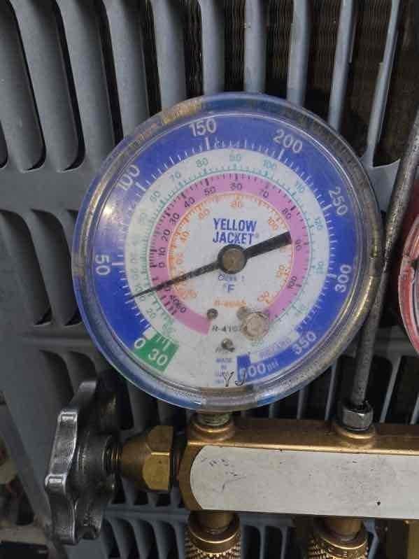 Responded to no cooling complaint on second floor for 10+ year old unit located at side of house. Upon arrival, performed diagnostic testing using pressure gauges and digital multimeter to assess system performance. Pressure readings indicated low refrigerant levels in the system. Inspected condenser coils, which showed dust accumulation and signs of age-related wear. Tested electrical components and verified proper voltage at the unit. Documented equipment condition with photos showing gauge readings and testing equipment placement on ductwork near air handler assembly.