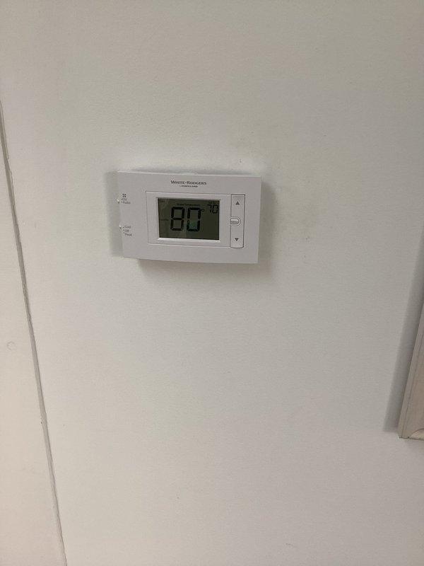 Responded to no-cool call on a 2-year-old system with 2 AC units serving 3 zones. Upon arrival, diagnosed power issue preventing blower fan operation. Installed new White-Rodgers non-programmable digital thermostat and replaced second thermostat per customer request for programmable unit on main floor. Verified all electrical connections at air handler, inspected control board and capacitor wiring. Restored power to system, tested all zones for proper operation, and confirmed cooling cycle engagement across all units.