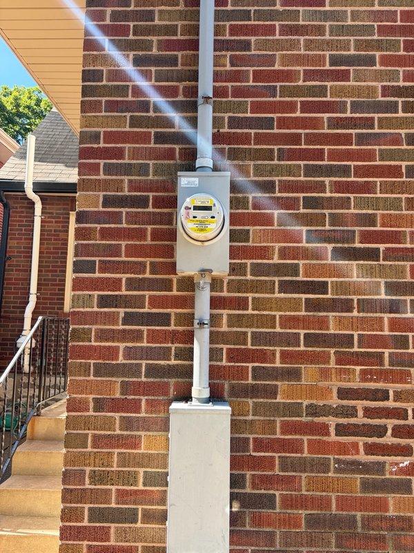 Performed comprehensive whole home electrical inspection at residential property. Conducted thorough evaluation of main electrical panel located in basement, documenting circuit breaker configuration, panel condition, and labeling system. Inspected exterior electrical service entrance including meter enclosure, weatherhead, and conduit installation mounted on brick exterior wall. All components photographed and assessed for code compliance, proper installation, and safety concerns. Panel interior showed clean condition with organized breaker layout and proper documentation affixed to door. Exterior service equipment evaluated for secure mounting, proper grounding, and weatherproofing integrity.