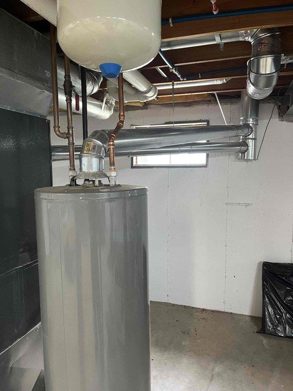 Installed a 40-gallon gas short water heater in basement to resolve no hot water condition. Connected all supply and discharge plumbing including expansion tank, installed proper venting, and applied permit sticker for permit #26PLU-12279. System tested and verified operational upon completion.