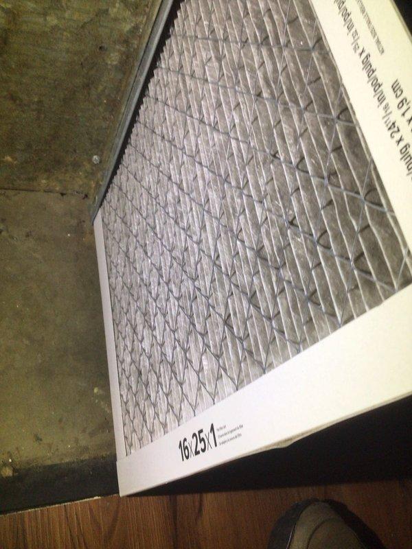 Responded to no cooling complaint on residential ground-level unit over 10 years old. Upon inspection, found heavily soiled air filter restricting airflow, as evidenced by accumulated dust and debris in filter pleats. Replaced dirty 16x25x1 filter and verified system operation with temperature readings showing proper cooling at 73°F. System restored to normal operation with improved airflow.