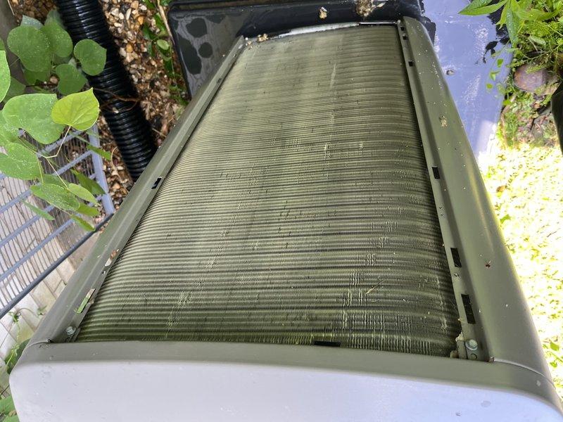 # HVAC Service - No Cool Completed

Responded to service call for 10+ year old outdoor condensing unit located on side of property that was not cooling and had been shut off. Upon arrival, performed visual inspection of unit exterior and internal components.

Found condenser coil heavily contaminated with organic growth, algae buildup, and accumulated debris causing significant airflow restriction. Coil fins displayed greenish discoloration with darkened patches throughout, indicating extended period without maintenance. Top discharge filter panel was severely clogged with thick dust and dirt accumulation showing distinct linear patterns across entire surface. This heavy contamination was restricting airflow to compressor and fan assembly, preventing proper heat exchange and causing system shutdown.

Documented existing conditions with photographs showing extent of coil contamination and filter blockage. Advised customer of findings and provided repair estimate for required cleaning se