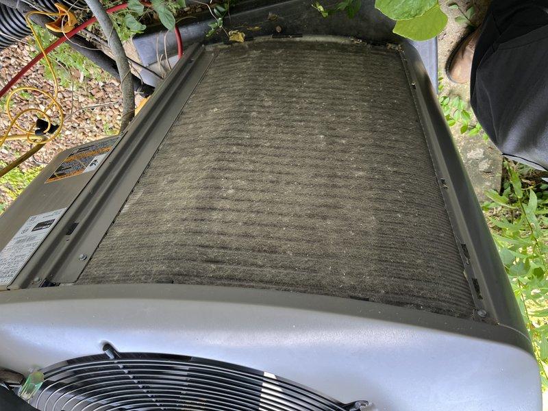# HVAC Service - No Cool Completed

Responded to service call for 10+ year old outdoor condensing unit located on side of property that was not cooling and had been shut off. Upon arrival, performed visual inspection of unit exterior and internal components.

Found condenser coil heavily contaminated with organic growth, algae buildup, and accumulated debris causing significant airflow restriction. Coil fins displayed greenish discoloration with darkened patches throughout, indicating extended period without maintenance. Top discharge filter panel was severely clogged with thick dust and dirt accumulation showing distinct linear patterns across entire surface. This heavy contamination was restricting airflow to compressor and fan assembly, preventing proper heat exchange and causing system shutdown.

Documented existing conditions with photographs showing extent of coil contamination and filter blockage. Advised customer of findings and provided repair estimate for required cleaning se