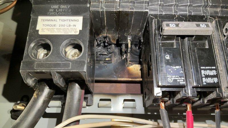 Responded to report of strong burning odor and low voltage reading from AC breaker in basement electrical panel. Upon inspection, discovered significant heat damage and burn marks on breaker connections and copper busbar, with visible discoloration indicating previous electrical arcing. Measured only 95 volts at the affected 50-amp AC circuit breaker, confirming inadequate power supply to HVAC system. Documented extensive thermal damage to breaker housing, terminal connections, and surrounding panel components through photographic evidence. Identified failed breaker and compromised busbar connection as primary causes of voltage drop and burning odor. Recommended immediate replacement of damaged 50-amp breaker, inspection and potential replacement of heat-damaged busbar section, and thorough evaluation of all wire connections for heat degradation. Advised that panel shows signs of prolonged overheating condition requiring comprehensive repairs to restore safe operation.