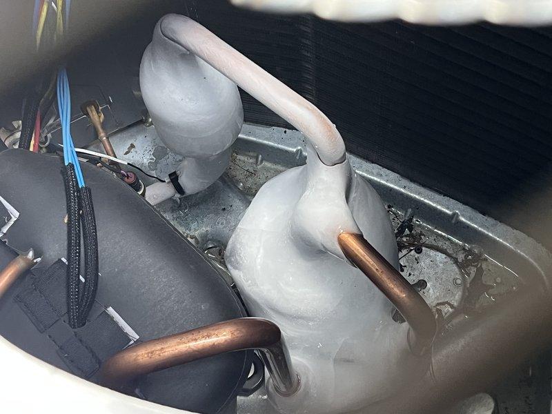 Responded to warranty call for new installation not maintaining proper temperature or dehumidification despite multiple previous service attempts. Upon arrival, discovered severe ice buildup on evaporator coil and refrigerant lines, with large ice formations completely encasing copper piping and connections. Diagnosed restricted airflow and improper refrigerant charge as contributing factors to freezing condition. Allowed system to thaw completely, verified airflow across coil, checked and adjusted refrigerant charge to manufacturer specifications, and confirmed proper operation of all components before departure.