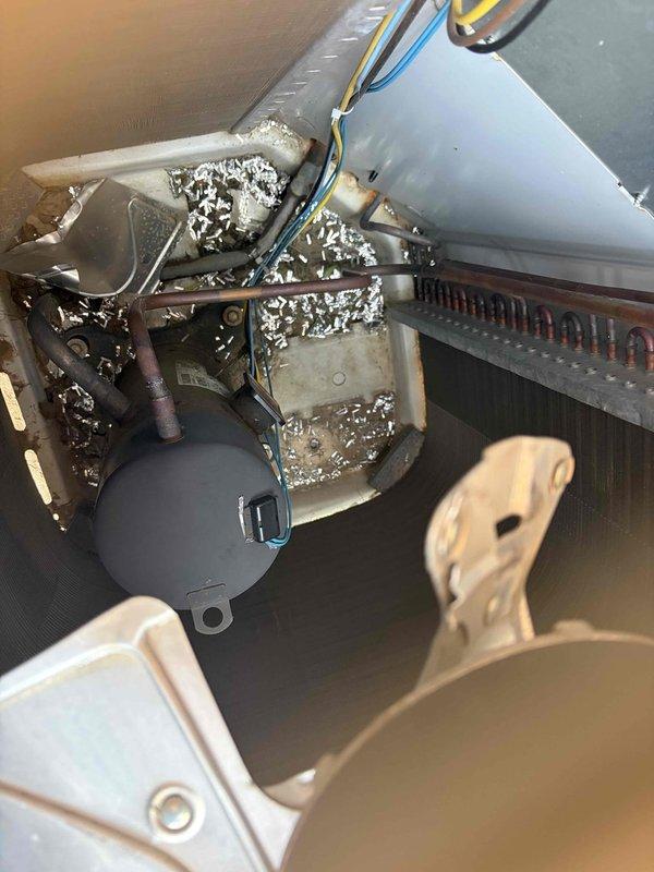# HVAC No Cool Service Call

Responded to service call for air conditioning unit not cooling with reported fan issue. Upon arrival, found unit shut off in backyard location. Performed diagnostic inspection of single AC system of unknown age. 

Accessed air handler and evaporator coil assembly for thorough examination. Observed copper evaporator coil with multiple parallel tube rows in proper configuration. Inspected condensate drain pan and float switch assembly for proper operation. Noted significant accumulation of dust, debris, and deteriorated insulation material throughout air handler cabinet and on internal components including mounting brackets, copper tubing, and heat exchanger coil fins. This heavy contamination indicated extended period without maintenance and potential airflow restriction issues.

Examined blower assembly, capacitor, and electrical connections. Multiple wire connections inspected including control wiring. Evaluated finned coil section and mechanical mounting