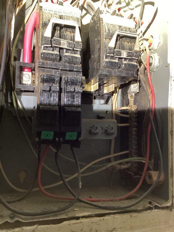 Performed on-site evaluation of existing electrical panel and contactor assembly located in kitchen/living room area. Panel inspection revealed significant age-related deterioration including corrosion, discoloration, and accumulated debris throughout the metal enclosure. Two electrical contactors with multiple wire connections were assessed for condition and functionality. Documented extensive wear on panel enclosure with paint chipping, bare metal exposure at mounting points, and environmental degradation of internal components. Photographed installation to provide comprehensive visual documentation for replacement estimate. Homeowner approval required before proceeding with any recommended repairs or panel upgrade work.