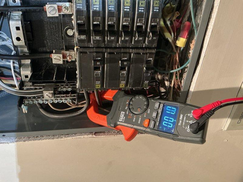 Responded to service call for AC unit not working and loss of power to master bathroom, bedroom, and wine cooling unit following multiple tripped breakers. Upon arrival, performed comprehensive electrical panel inspection and testing using clamp meter to measure current loads on affected circuits. Investigation revealed underlying issues with panel electrical supply and distribution system. Documented panel condition with photographs showing circuit breaker configuration, wire connections, bus bars, and terminal blocks. Measured circuit loads showing 23.1 amp reading on tested breaker. Identified compromised connections and potential overload conditions affecting multiple branch circuits. Advised that panel requires further electrical repairs to restore safe operation to affected areas and recommended comprehensive evaluation of electrical distribution system to address root cause of breaker trips and power loss.