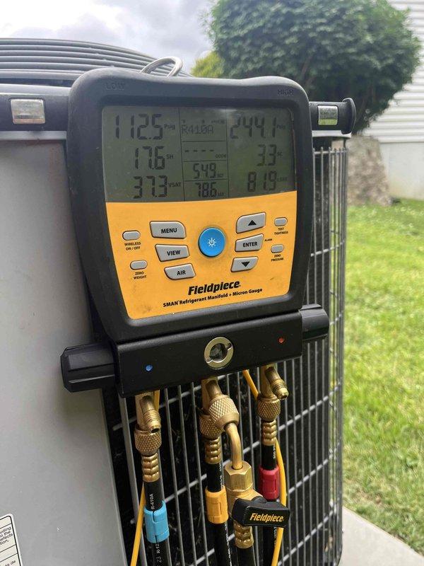 Responded to customer complaint of excessive humidity inside the home. Upon arrival, connected refrigerant manifold gauges to the 7-year-old ground-level condensing unit to assess system performance. Measured operating pressures and temperatures, which revealed abnormal readings indicating potential refrigerant charge issues or system inefficiency. Performed diagnostic testing using digital manifold to evaluate superheat and subcooling values. Documented system conditions with photos showing pressure readings of 112.5 PSI low side and 244.1 PSI high side during initial testing, followed by adjusted readings during heat mode operation. The elevated humidity complaint correlates with improper system operation affecting dehumidification capacity. Recommended further evaluation of refrigerant charge levels and potential system adjustments to restore proper cooling and dehumidification performance.