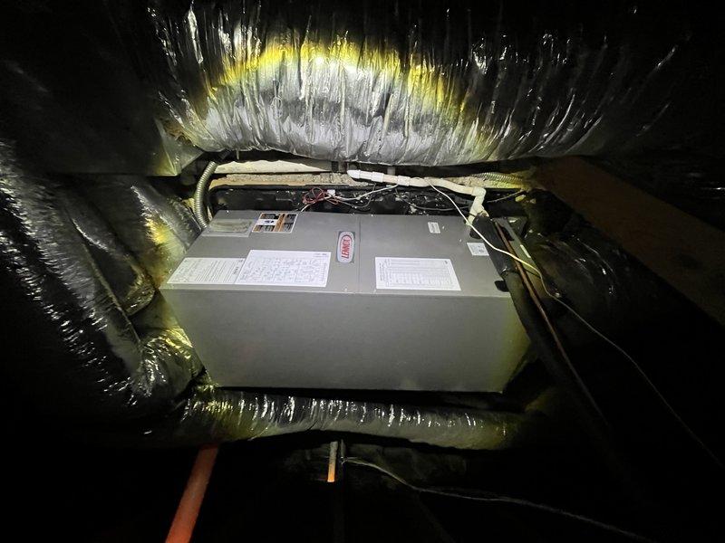 Responded to service call for non-operational air conditioning system with reported fan failure and potential thermostat malfunction. Accessed attic-mounted air handler unit via 12-foot ladder and performed diagnostic inspection of approximately 10-year-old system. Upon examination, identified issues with air handler operation and verified electrical connections, blower motor functionality, and thermostat communication. Inspected evaporator coil, condensate drain system, and ductwork connections for proper operation. Noted existing moisture staining on drain pan and general equipment condition consistent with system age. Restored system to operational status and verified proper airflow through supply ducts.