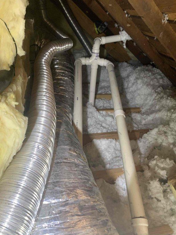Completed drain line repairs in attic space for HVAC system experiencing no cooling issue. Installed approximately 8 feet of 3/4-inch PVC pipe with 45-degree elbow fitting and 10-12 feet of 5/8-inch vinyl tubing to restore proper condensate drainage. Used nitrogen to clear blockages and verify proper flow through repaired drain line system.