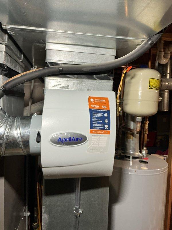 Installed AprilAire 600M humidifier unit on existing ductwork system in mechanical room. Connected unit to HVAC ductwork with proper mounting and secured all necessary plumbing and electrical connections. Verified proper operation of humidifier and integration with forced-air heating and cooling system.
