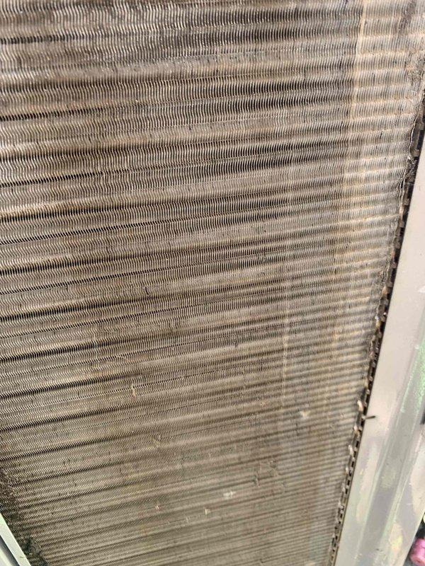 Completed comprehensive tune-up service on single residential air conditioning unit located at ground level. Performed standard maintenance protocol including inspection of evaporator coil assembly, which showed typical dust and dirt accumulation on fin surfaces. Documented equipment condition through photographic records showing corrugated metal fins with operational wear patterns consistent with normal system usage.