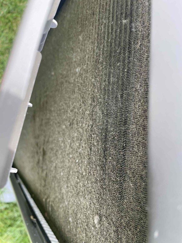 Completed comprehensive tune-up service on a U10 cooling system located on the side of the home. Upon inspection, discovered heavily soiled air filter with significant dust and debris accumulation, which was affecting airflow and system efficiency. Additionally, found evaporator coil extensively covered with dirt, dust, and contaminants that had matted between the fins, severely restricting heat transfer capacity. Performed standard maintenance procedures including system inspection, cleaning, and operational testing to restore unit to proper working condition.