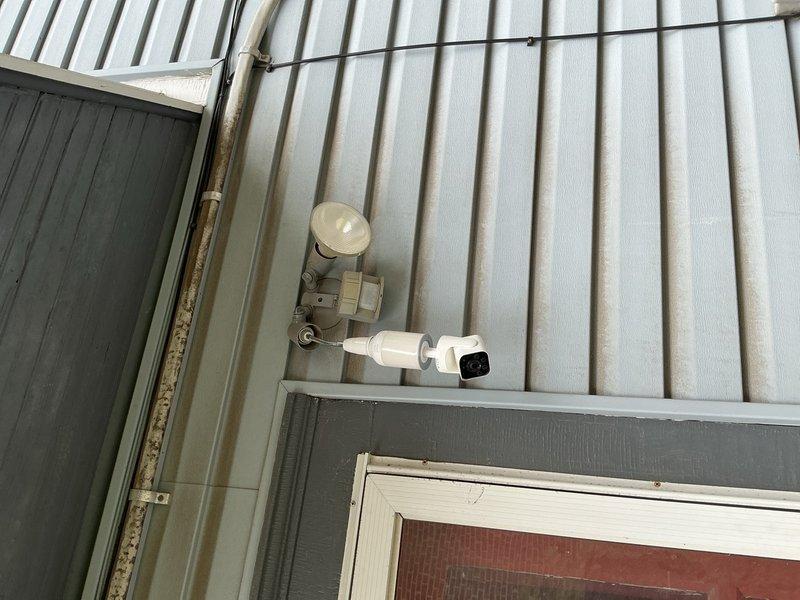 Installed exterior motion-activated floodlight fixture on corrugated metal siding at building entryway to provide security illumination for driveway area. Ran electrical conduit along exterior wall surface, connected fixture to appropriate circuit at main electrical panel, and verified proper operation of motion sensor and lighting function upon completion.