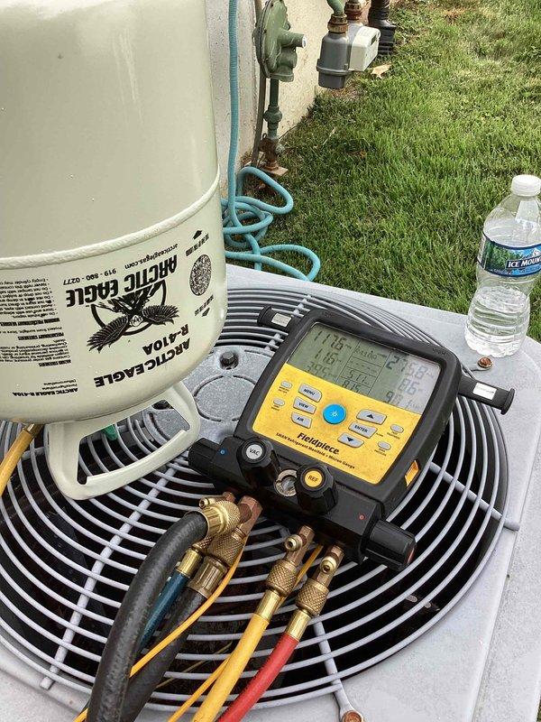 Responded to callback for indoor humidity complaint on residential split system less than 10 years old. Upon arrival, connected manifold gauges and performed refrigerant pressure analysis on outdoor condensing unit. System diagnostics revealed operating parameters requiring adjustment. Added refrigerant charge from Arctic Eagle cylinder to bring system pressures within manufacturer specifications. Verified proper airflow across condenser coil and confirmed all electrical connections secure at disconnect. Monitored system operation through complete cooling cycle to ensure adequate dehumidification and temperature control restored to occupied space.