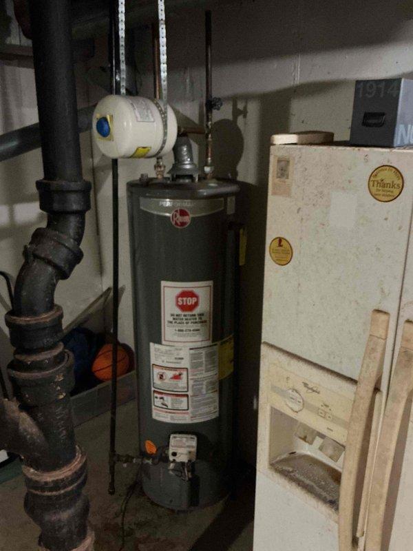 Responded to no hot water complaint and completed full replacement of residential gas water heater in basement utility area. Removed existing failed unit and installed new 40-gallon gas tall water heater with proper venting and connections. Connected copper supply lines with brass fittings and valves, installed pressure relief valve with discharge piping, and ensured all gas connections were properly sealed and tested for leaks. Verified proper clearances around unit for safe operation and maintenance access. System tested and confirmed operational with adequate hot water delivery throughout residence.