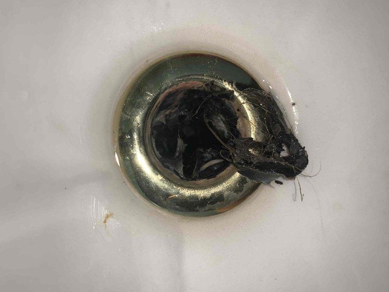 Responded to service call for slow-draining bathroom sink and clogged kitchen double sink. Upon inspection, discovered significant accumulation of hair and organic debris in bathroom sink drain, causing restricted water flow. Removed drain stopper assembly and manually extracted blockage material from P-trap area. In kitchen, assessed double sink configuration and cleared complete obstruction using appropriate drain cleaning methods. Verified proper drainage flow restored to both fixtures. All plumbing components inspected and confirmed to be functioning correctly upon completion.