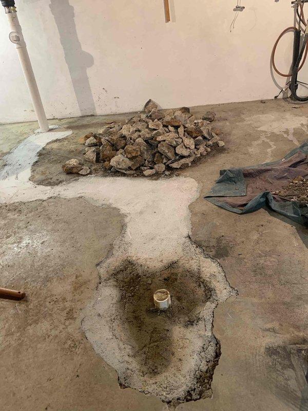 Responded to basement drain backup issue where line had previously been repaired. Performed mechanical snaking of the drain line to clear obstruction, then conducted video camera inspection to assess interior condition of the pipe and identify any underlying issues. Documentation photos show basement floor area with visible water staining around floor drain and evidence of recent moisture intrusion, confirming the reported backup condition prior to service intervention.