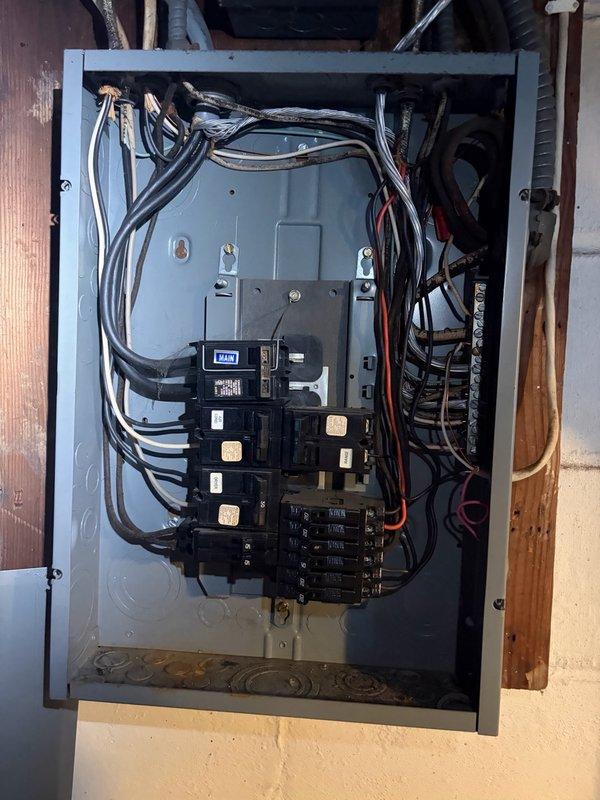 Completed comprehensive electrical panel inspection at residential property. Examined main service panel, verifying proper circuit breaker operation, wire connections, and overall system integrity. All circuit breakers were tested for proper function, wire terminations were inspected for secure connections, and panel interior was assessed for code compliance and safety concerns. Documented panel configuration with photographs showing dual-column breaker arrangement, main disconnect, and incoming service conductors. Discussed installation of exterior light fixture near basement door entrance for future service scheduling.