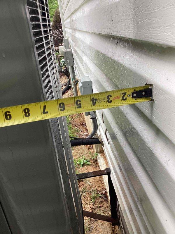 Responded to no cooling complaint on 8-year-old residential outdoor unit. Upon arrival, performed diagnostic inspection of condenser system and verified clearance measurements between unit and building exterior, confirming adequate airflow spacing per manufacturer specifications. Documented equipment condition and installation positioning with photographic evidence showing unit mounted on foundation with proper electrical disconnect present. System evaluated for cooling operation and common failure points associated with no-cool conditions on units of this age.