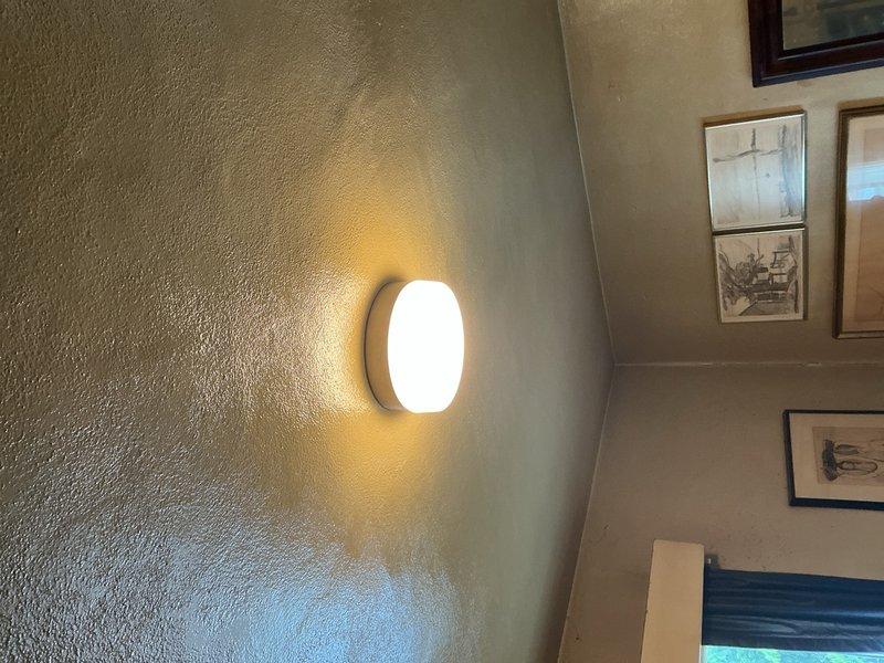 Installed two customer-provided light fixtures at the property: a circular wall sconce with frosted glass cover in an interior living space, and an octagonal bronze-toned outdoor lantern with amber glass panels at the building's exterior entrance. Both fixtures were mounted securely to textured wall surfaces, wired to existing electrical circuits, tested for proper operation, and confirmed to be functioning correctly upon completion.