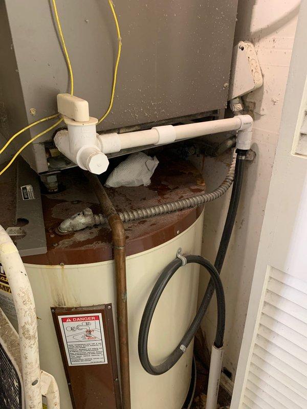 Responded to service call for rooftop HVAC unit reported as not turning on with water leak in furnace. Accessed unit via interior stairs to rooftop closet location. Upon inspection, evaluated air handler interior insulation condition and documented intact thermal lining with normal dust accumulation. Investigated reported water leak source and inspected adjacent water heater showing significant rust staining and corrosion on upper surfaces, which may have been contributing to moisture concerns in the mechanical space. Verified PVC condensate drainage lines and plumbing connections for proper routing and potential leak points. Documented equipment conditions with photographic evidence for customer records. Unit age unknown at time of service.