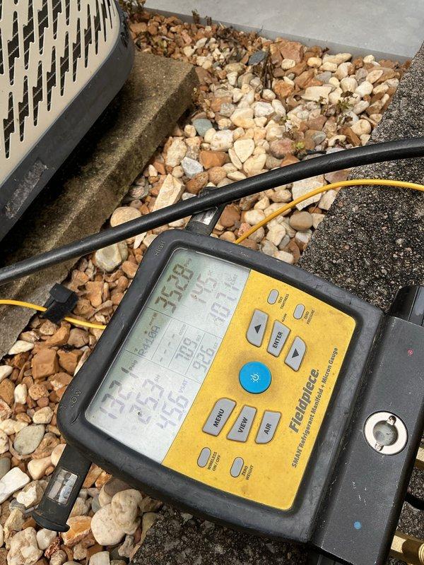 Responded to no cooling complaint on 10-year-old residential AC unit located in side yard. Upon arrival, found unit powered off with thermostat fan set to ON position. Performed comprehensive system diagnostics using digital testing meters to measure electrical parameters and refrigerant pressures at both outdoor condenser unit and indoor air handler. Identified issue preventing proper cooling operation, took diagnostic measurements of system performance, and documented findings with photos of testing equipment readings at multiple system access points. Unit required repairs to restore cooling functionality.