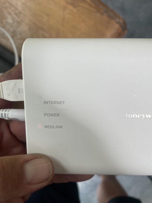 Responded to no cooling call with thermostat displaying connectivity error message. Upon arrival, found Honeywell thermostat showing "1 Alert active" with indoor temperature reading 84°F and setpoint at 75°F, indicating system was not communicating properly. Inspected RedLink wireless gateway and verified power and network connections. Troubleshot communication failure between thermostat and HVAC equipment control board, restored RedLink connectivity, and cleared alert messages. System restored to normal cooling operation with proper communication established between all components.