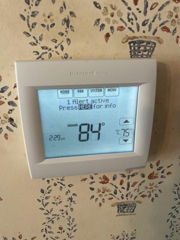 Responded to no cooling call with thermostat displaying connectivity error message. Upon arrival, found Honeywell thermostat showing "1 Alert active" with indoor temperature reading 84°F and setpoint at 75°F, indicating system was not communicating properly. Inspected RedLink wireless gateway and verified power and network connections. Troubleshot communication failure between thermostat and HVAC equipment control board, restored RedLink connectivity, and cleared alert messages. System restored to normal cooling operation with proper communication established between all components.