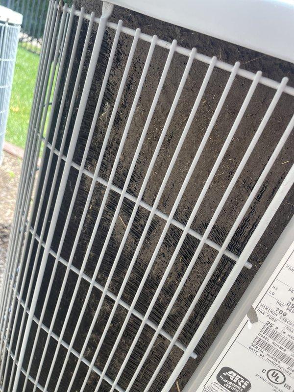 Responded to no cooling complaint on 10+ year old residential unit. Upon inspection, found outdoor unit's top filter heavily contaminated with accumulated dust, dirt, and debris causing severely restricted airflow. Indoor thermostat displayed 87°F, confirming inadequate cooling performance. Cleaned and serviced unit to restore proper operation.