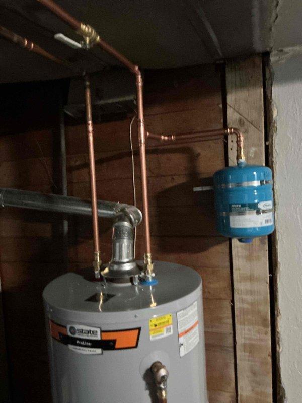 Completed installation of 40-gallon gas water heater with 3/4" pressure reducing valve in accordance with City of University permit #26-006396. Installed State brand water heater unit with proper copper piping connections, brass fittings, and pressure relief valve. Integrated Proflo brand expansion tank mounted between wall studs with metal hose clamps and connected to system via copper piping. All connections tested and verified operational upon completion.