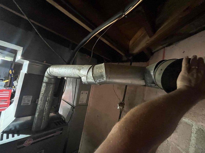 Responded to no cooling call on 8-year-old ground-level unit in basement. Upon arrival, found system running continuously with blower operating but no cooling output. Performed diagnostic evaluation of HVAC system and inspected accessible components including ductwork, which showed significant age-related deterioration with peeling insulation coating and wear at connection points. Documented system conditions with photographs showing weathered ductwork with exposed metal sections and compromised connections near wall penetrations. Verified customer had turned off cooling and humidifier fan operation as requested prior to service visit. Assessed unit's mechanical systems and identified cooling failure requiring further diagnosis to determine specific component malfunction preventing refrigeration cycle operation.