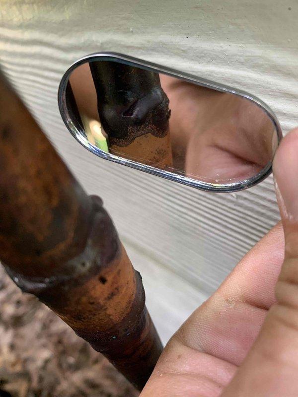 Responded to no cooling complaint on recently installed Trane air conditioning system. Upon inspection, discovered severely corroded refrigerant lines with significant internal and external deterioration, including visible debris buildup inside copper piping. Documented compromised line set condition with inspection mirror to verify internal damage and photographed extensive corrosion on exterior refrigerant lines and conduit connections, which was causing refrigerant leak and loss of cooling capacity.