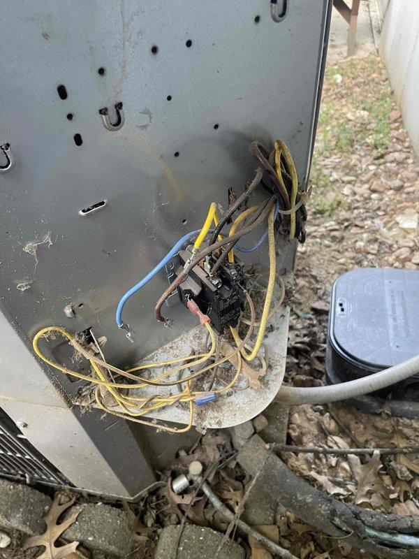 Responded to no cooling call on 10+ year old outdoor unit located at rear of property. Upon arrival, performed system diagnostic and found electrical disconnect panel with deteriorated wiring connections and aged insulation showing signs of environmental exposure. Inspected outdoor condensing unit with white metal housing and top discharge grille. Identified compromised electrical connections as primary cause of system failure. Advised customer of findings and recommended electrical repairs to restore proper system operation and ensure safe functionality.