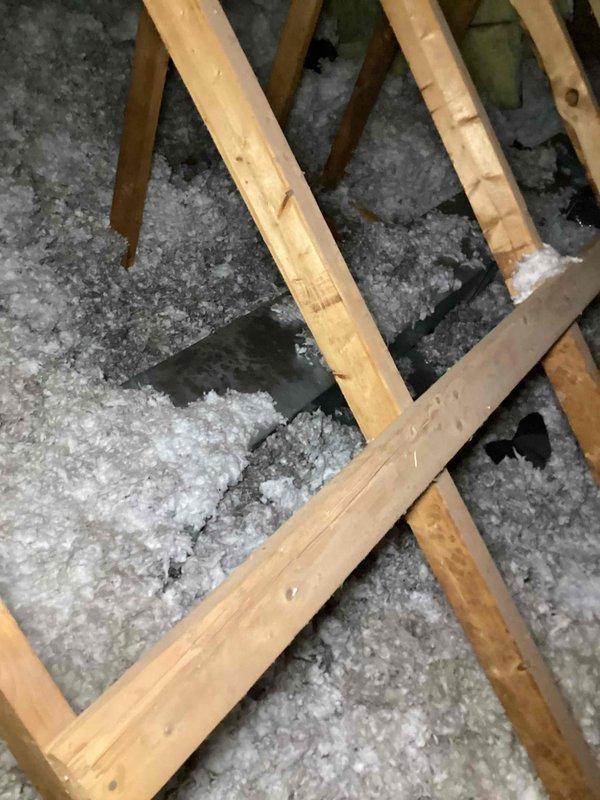 Responded to no cooling complaint on second floor unit. Upon inspection, discovered extensive ice buildup on evaporator coil, with surface temperature reading 38°F on measurement device. Identified restricted airflow as primary cause due to inadequate attic insulation coverage and distribution around air handler. Thawed frozen coil, verified proper refrigerant charge, and confirmed system operation restored. Recommended improved insulation installation to prevent future airflow restriction and maintain proper system performance.