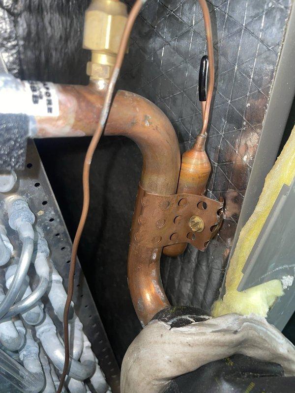 Responded to recall for AC unit not cooling with frozen evaporator coil on 9-month-old system. Upon inspection, verified proper operation of TXV valve and confirmed refrigerant metering components functioning correctly. System tested and operating within normal parameters with no refrigerant leaks detected.