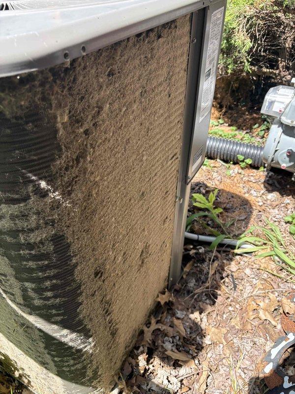 Responded to service call for insufficient cooling on 12-year-old Lennox air conditioning system. Upon arrival, performed visual inspection of outdoor condensing unit and discovered severely restricted airflow due to heavy accumulation of dirt, dust, and debris completely coating the condenser coil fins and side intake panels. The thick layer of contamination was significantly impeding heat transfer efficiency and reducing system capacity. Cleaned condenser coils thoroughly to restore proper airflow and heat exchange capability. Removed accumulated debris from intake panels and surrounding unit exterior. System airflow and cooling performance restored to normal operating parameters following cleaning procedure.