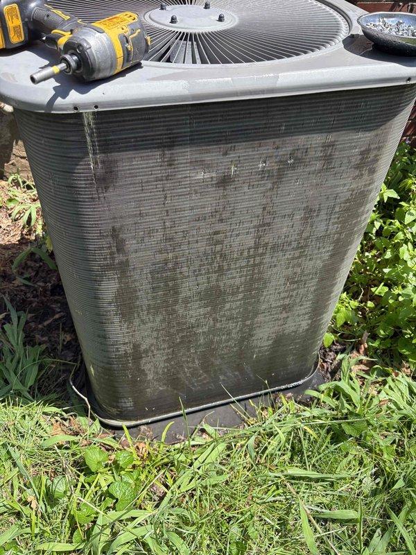 Responded to service call for insufficient cooling on 12-year-old Lennox air conditioning system. Upon arrival, performed visual inspection of outdoor condensing unit and discovered severely restricted airflow due to heavy accumulation of dirt, dust, and debris completely coating the condenser coil fins and side intake panels. The thick layer of contamination was significantly impeding heat transfer efficiency and reducing system capacity. Cleaned condenser coils thoroughly to restore proper airflow and heat exchange capability. Removed accumulated debris from intake panels and surrounding unit exterior. System airflow and cooling performance restored to normal operating parameters following cleaning procedure.