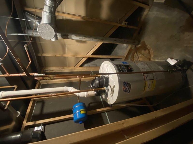 Removed and drained the existing tall water heater from the mechanical room. Capped the 1/2" copper gas line and 4" flue tee that serviced the removed unit. Repiped the cold water supply to the remaining 50-gallon power vent water heater, converting it to serve as the sole water heating system for the residence. Installed a new two-gallon expansion tank on the cold water line. Coordinated careful removal of the old water heater to avoid disturbing the existing power vent gas controls and surrounding plumbing infrastructure. Completed all necessary copper piping connections and verified proper water flow to the remaining unit. Cleaned the work area and hauled away the old water heater and all related debris.
