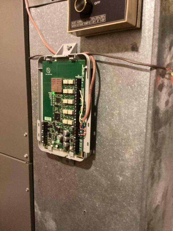 Responded to service call for zoned heating system malfunction where both upstairs and downstairs units were calling but only the downstairs system was operating. Inspected dual-zone HVAC system with control board and thermostat wiring at unit located at rear of property. Diagnosed zone control board issue preventing proper communication between thermostats and upstairs air handler. Verified supply air temperature reading of 53.6°F at equipment. Tested zone damper operation and control signals to isolate communication failure in upstairs zone circuit. Restored proper heating operation to both zones by addressing control board wiring connections and verifying thermostat call signals were reaching both air handling units.