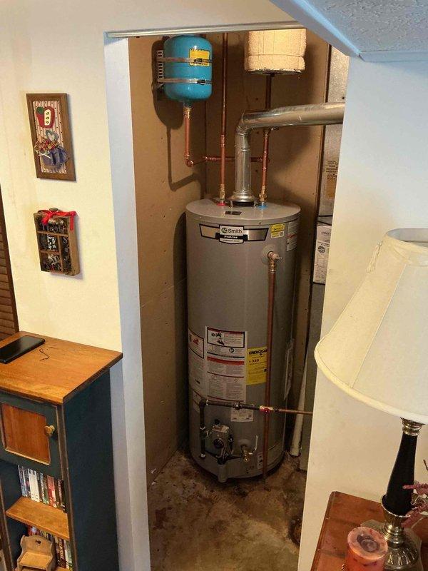 Installed a 50-gallon tall A.O. Smith natural gas water heater (Model HNA74Q1) with blue expansion tank and copper piping connections in residential utility closet. Additionally repaired two leaking interior hose bibs on a time and materials basis. Installation completed without permit as specified for Jefferson County requirements.