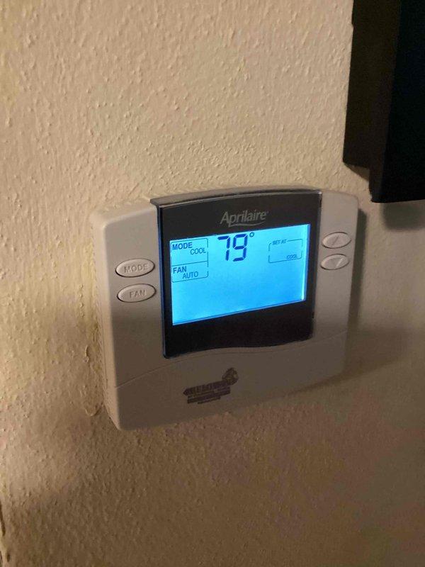 Responded to no cooling complaint on 10+ year old outdoor condenser unit located on side of home. Upon arrival, found unit operational but exhibiting significant age-related deterioration with heavy exterior soiling, algae growth on pad, and visible weathering throughout. Thermostat confirmed system running in cooling mode at 79°F setpoint with fan in auto position. Performed diagnostic evaluation of aging equipment to determine cooling deficiency and assessed whether repair or replacement would be most appropriate solution. Documented unit condition with photographs showing extensive environmental wear and discussed findings with customer regarding recommended course of action for restoring proper cooling performance.