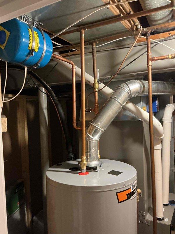 Installed a 50-gallon gas tall water heater in basement utility area with all necessary copper piping connections, brass fittings, and isolation valves. Connected expansion tank to system and verified proper venting through existing galvanized ductwork. All plumbing connections tested and operational upon completion.