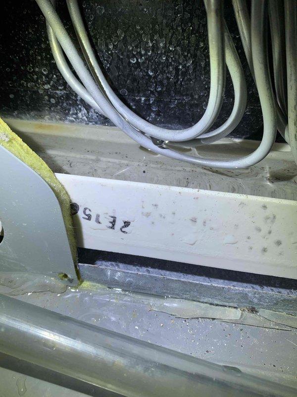 Responded to service call for water leaking from top of air conditioning unit located in basement. Upon inspection, found excessive condensation and water accumulation on evaporator coil assembly and drain pan components. Identified clogged condensate drain line as primary cause of overflow condition. Cleared obstruction from drain line, verified proper drainage flow, and tested system operation. Unit cooling properly with condensate now draining correctly through cleared line.