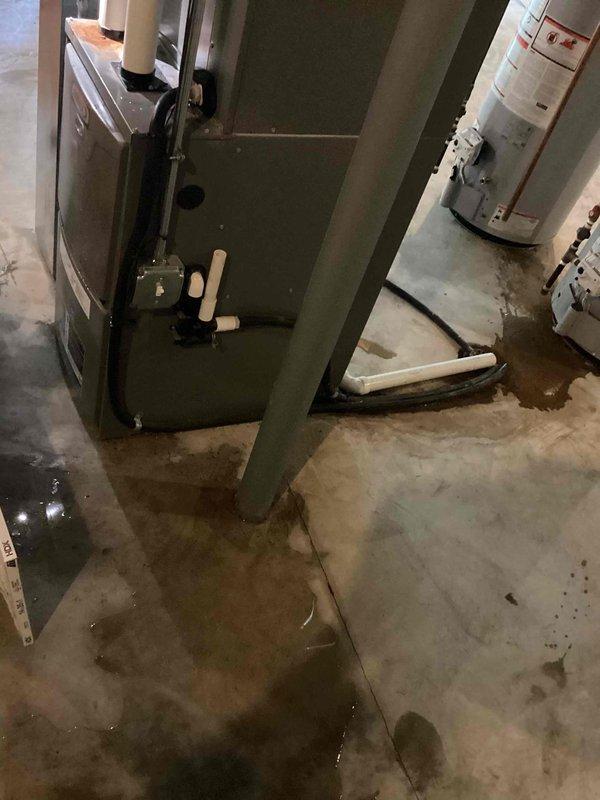 Responded to no-cool complaint on 11-year-old Lennox AC unit that had been serviced approximately one month prior for refrigerant leak and recharge. Upon arrival, discovered significant water flooding throughout basement mechanical room with standing water pooling around HVAC equipment. Inspected evaporator coil and drain system, identifying clogged condensate drain line as primary cause of water accumulation. Cleared blockage from condensate line using appropriate tools and verified proper drainage. Checked refrigerant levels and pressures on AC system, finding unit low on charge, indicating repeat leak issue as initially reported. Performed leak detection on refrigerant circuit, locating active leak at evaporator coil connection point. Due to age of unit and recurring leak pattern at same location, recommended evaluation of coil replacement versus system replacement options. Extracted standing water from floor area to prevent further damage to surrounding equipment and structure. Adv
