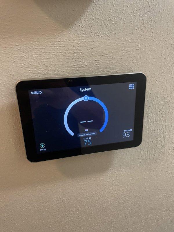 Responded to no cool call on 8-year-old Lennox air conditioning system with smart thermostat display issue. Upon arrival, found AC unit operating but thermostat screen reportedly blank, preventing temperature adjustments. During diagnostic evaluation, thermostat display restored functionality and showed proper operation with touchscreen interface responding normally, displaying current temperature of 77°F, set point of 75°F in cooling mode, and outside temperature of 93°F. Verified thermostat communication with HVAC system, confirmed cooling cycle activation, and tested all control functions including temperature adjustment and mode selection. System operating as designed at time of service completion with full display and control capability restored.