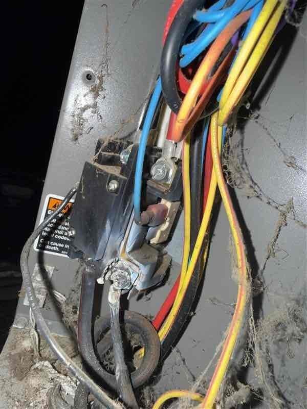 Technician arrived on-site for scheduled service call but job was cancelled after dispatch. Documentation photos were captured showing existing HVAC electrical components including capacitor/contactor assembly with multi-conductor wiring harness mounted to weathered metal panel, and auxiliary electrical connections with conduit routing in mechanical area.